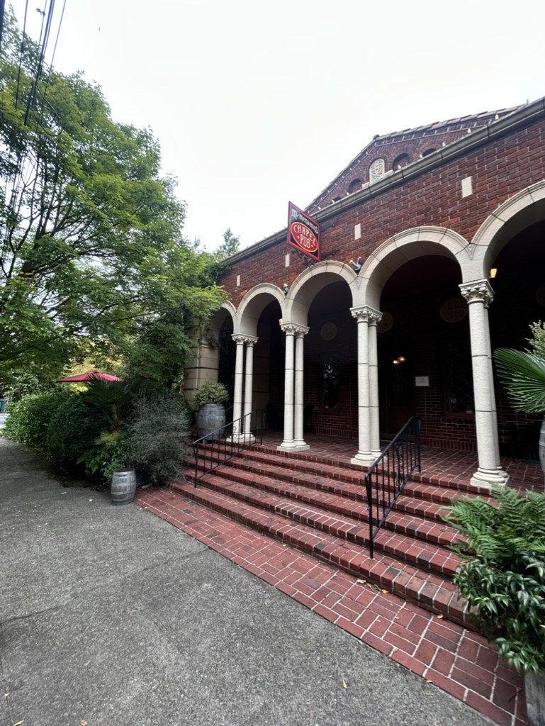 McMenamins Chapel Pub entrance with brick arches and outdoor greenery
