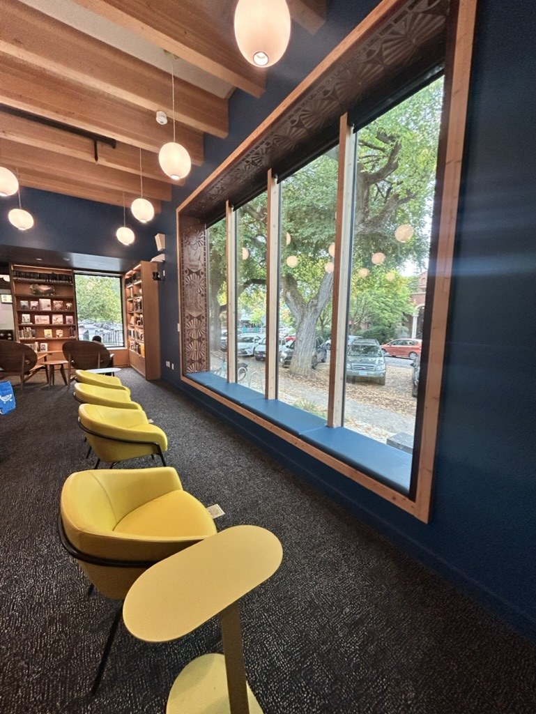Library reading area with large windows and yellow chairs