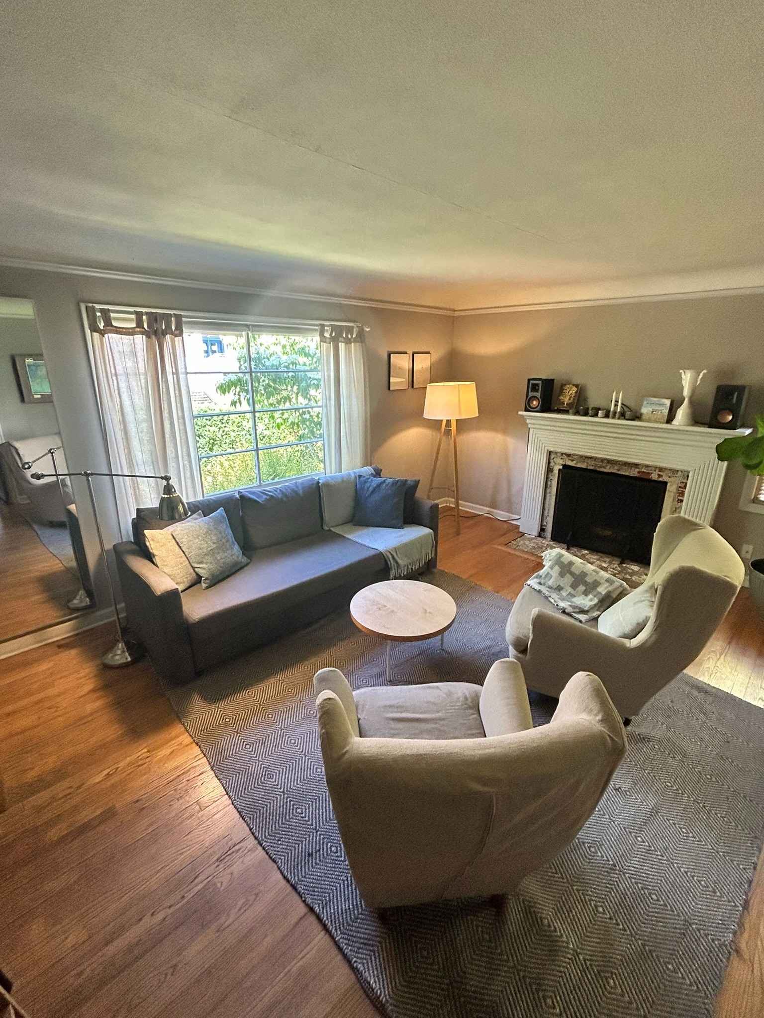 Furnished living room with a sofa, armchairs, hardwood floors and fireplace